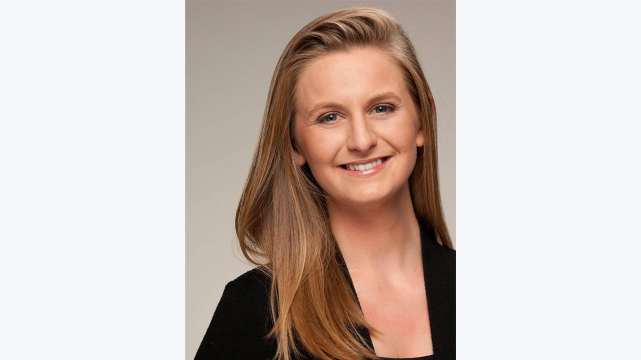 Julianne McCall featured smiling in front of a grey background.